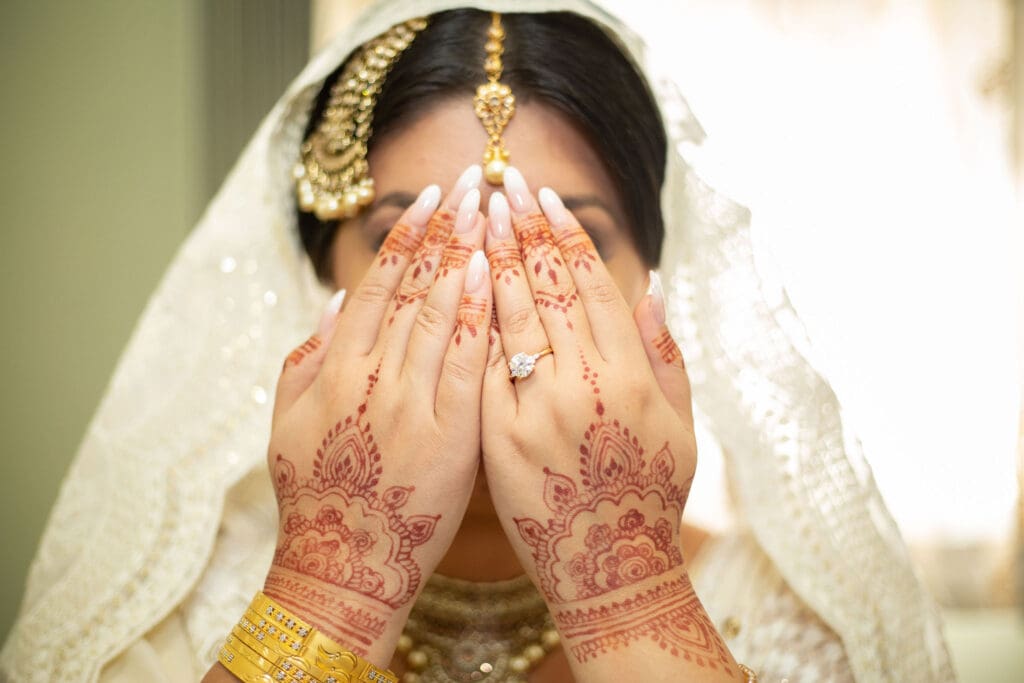 Brooklyn Nikkah Elopement. Portrait of bride covering her eyes before the ceremony in her full jewelry and henna.