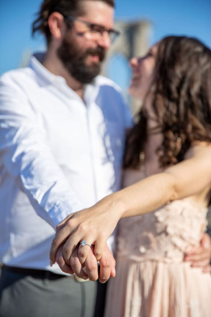 An engaged couple on the Brooklyn Bridge.
