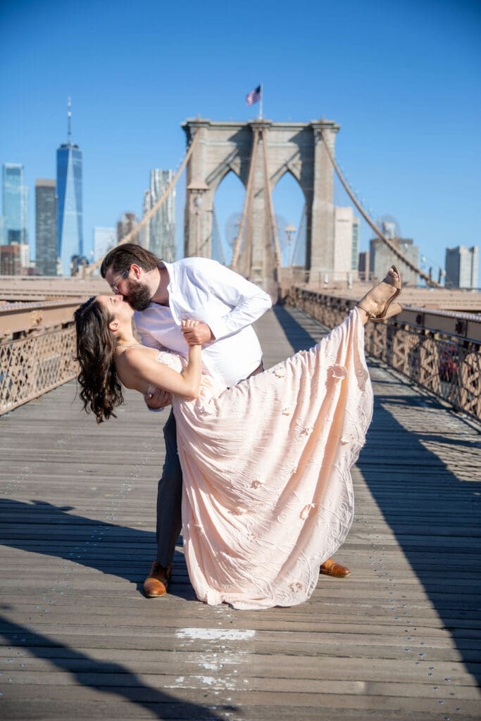 An engaged couple dance on the Brooklyn Bridge.