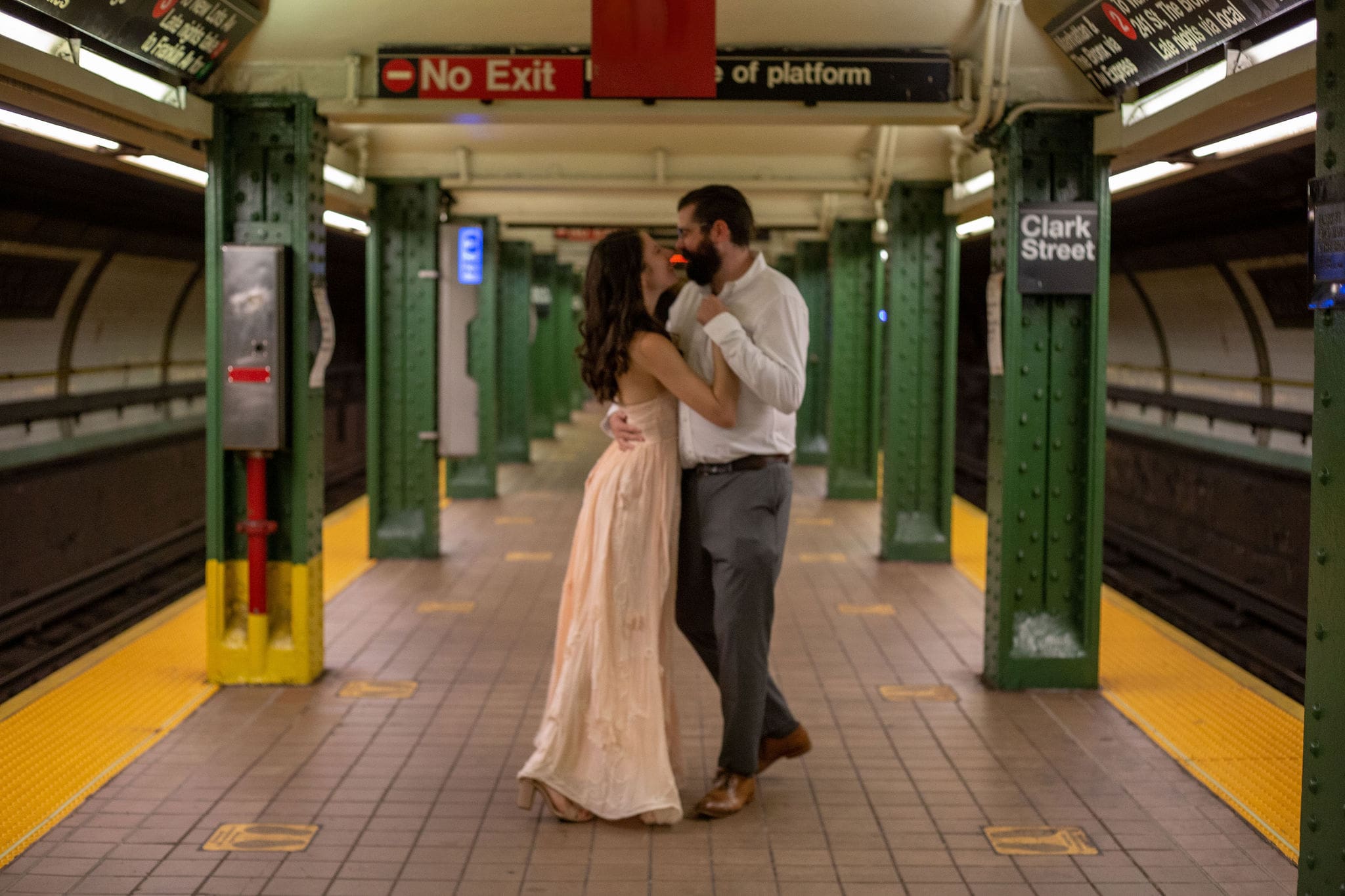 An engaged couple dances on a Brooklyn subway platform.