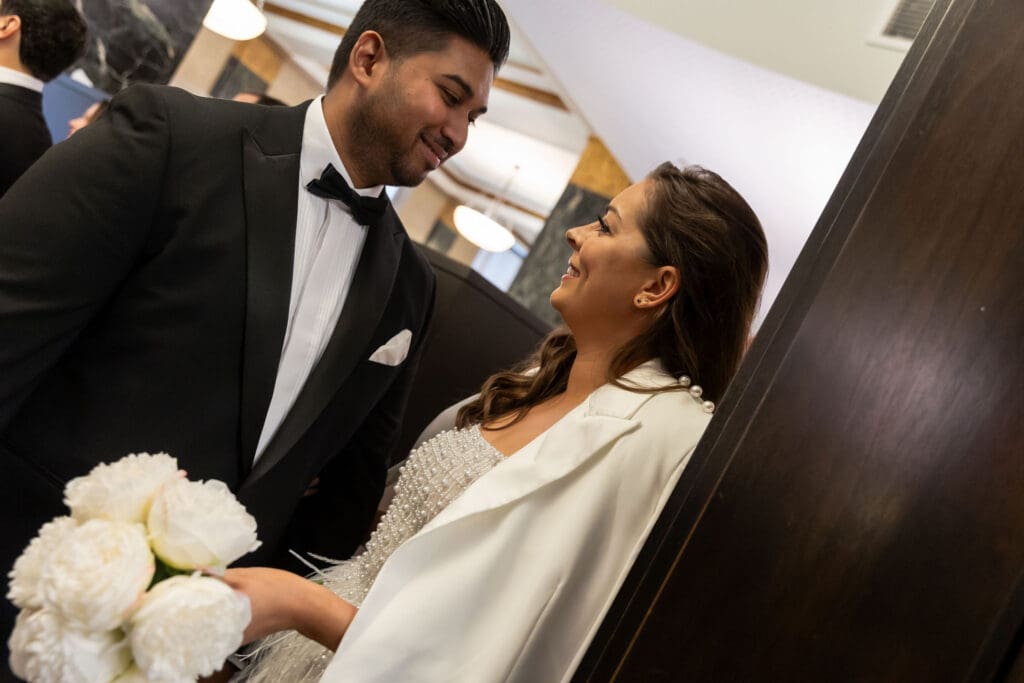 Couple relaxes near the green couches before getting married at NYC City Hall.