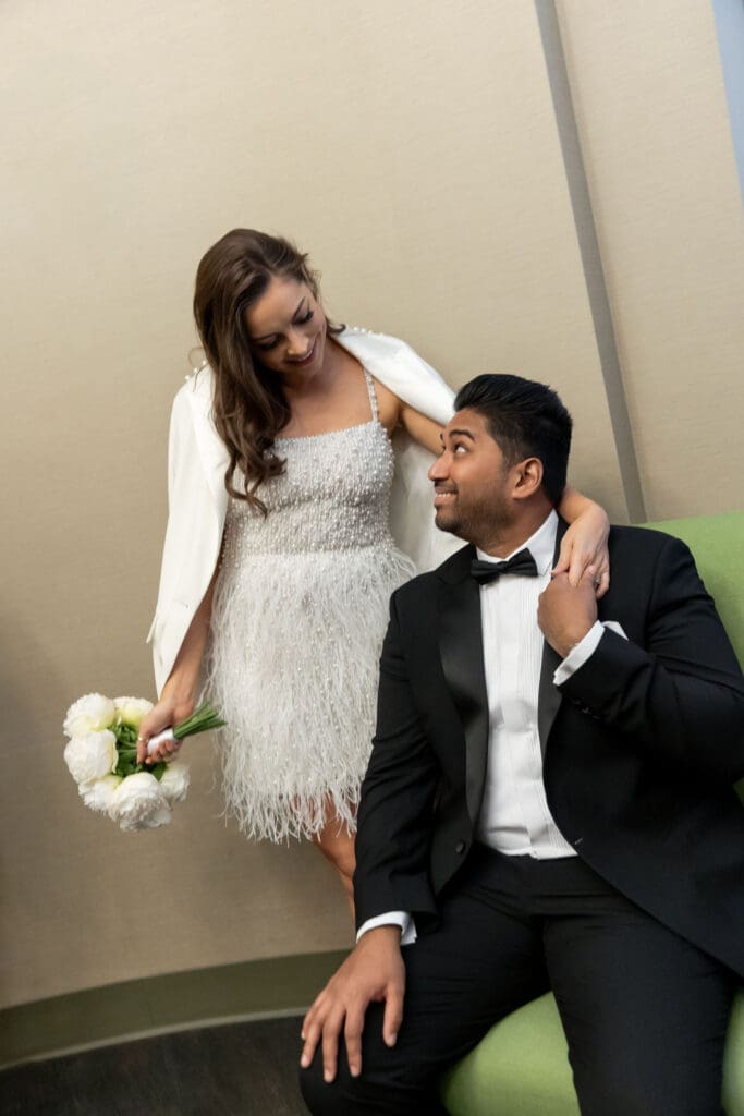 Couple relaxes near the green couches before getting married at NYC City Hall.