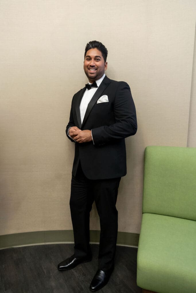 Groom poses near the green couches before getting married at NYC City Hall.