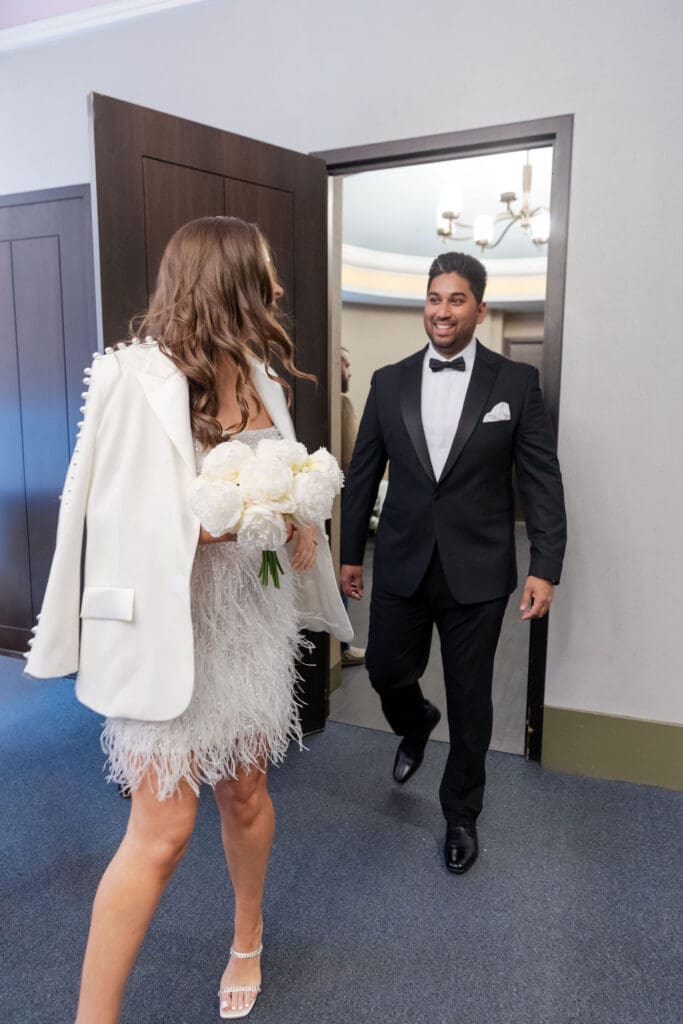 Newlywed couple walk into the pink ceremony room at NYC City Hall.