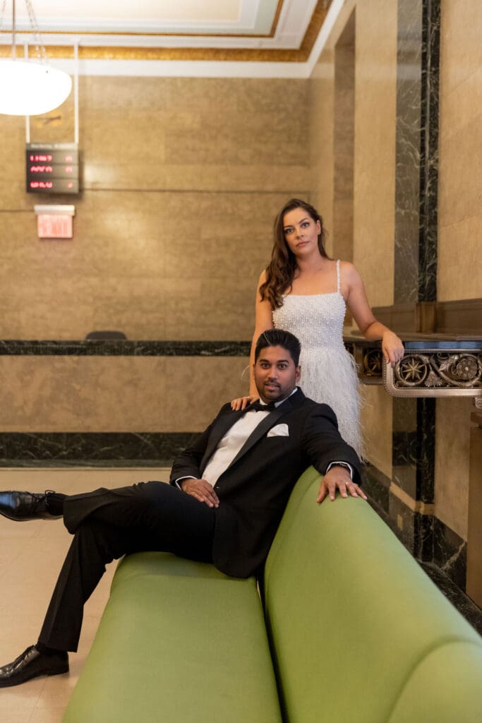 Newlywed couple pose at the green couches after getting married at NYC City Hall.