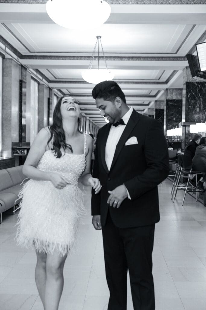 Newlywed couple celebrate in the hall after getting married at NYC City Hall. Black and White Image.