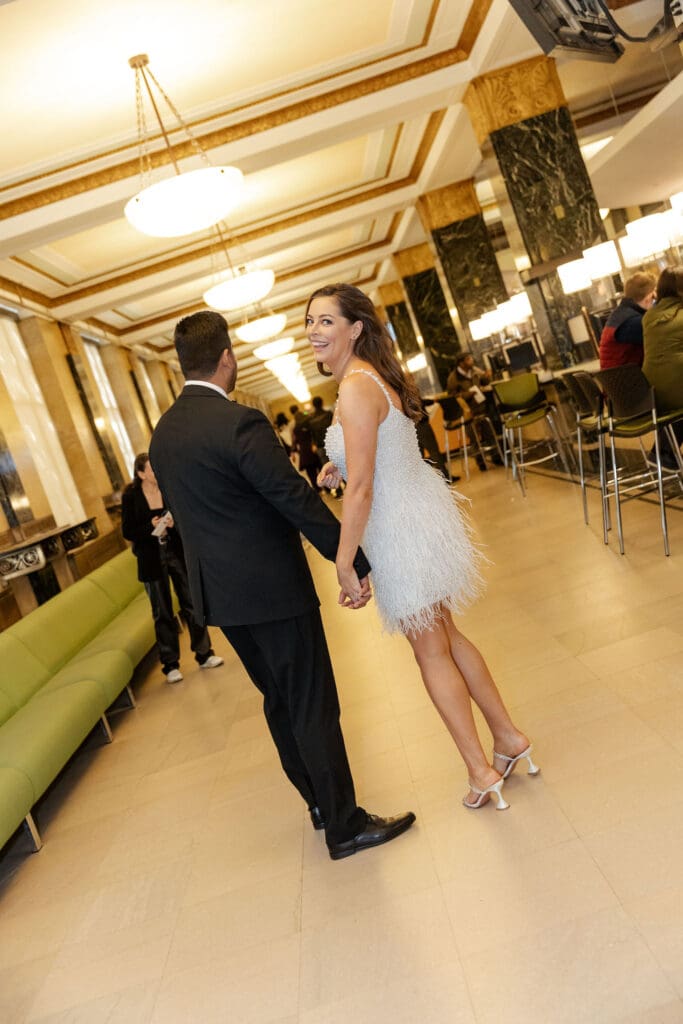 Newlywed couple celebrate in the hall after getting married at NYC City Hall.