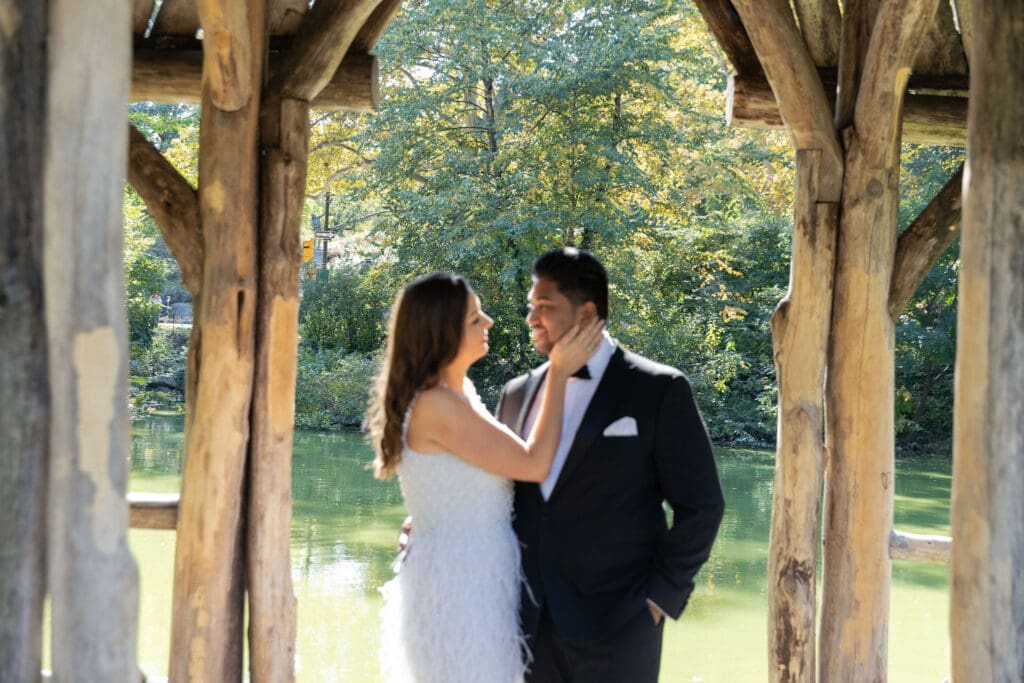 Newlywed couple laugh at Wagner Cove in Central Park NYC after getting married at City Hall.