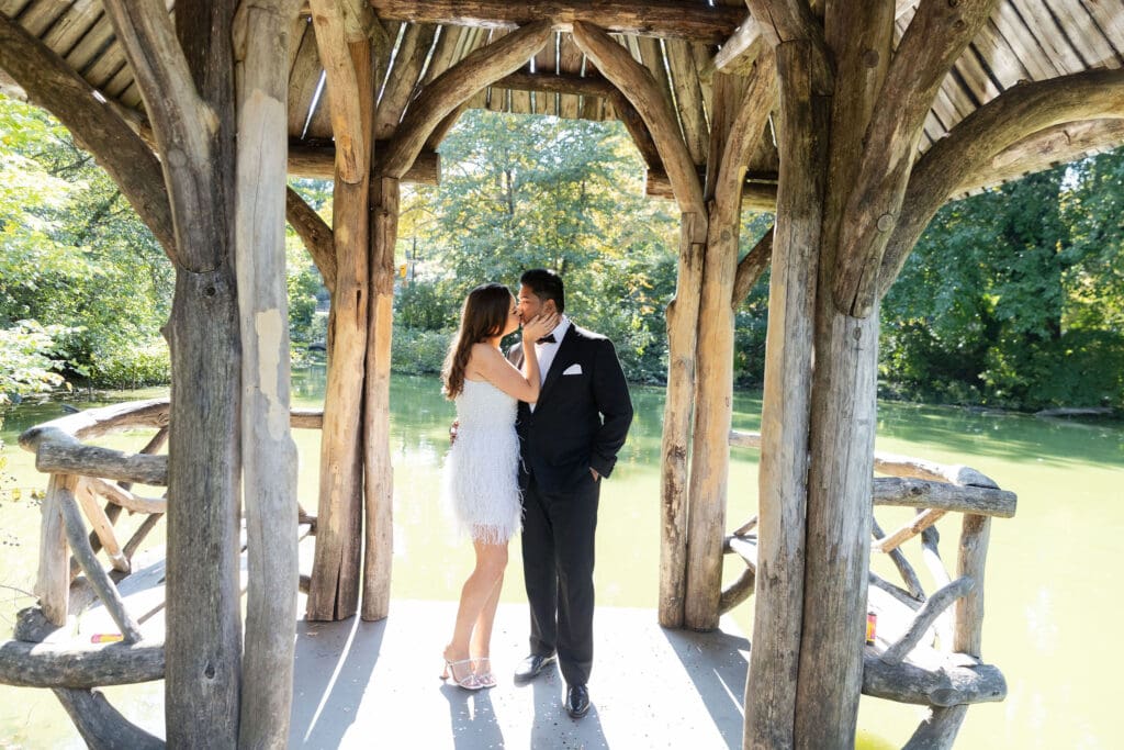 Newlywed couple kiss at Wagner Cove in Central Park NYC after getting married at City Hall.