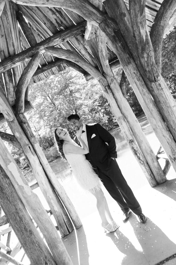 Newlywed couple laugh at Wagner Cove in Central Park NYC after getting married at City Hall. Black and White Image.