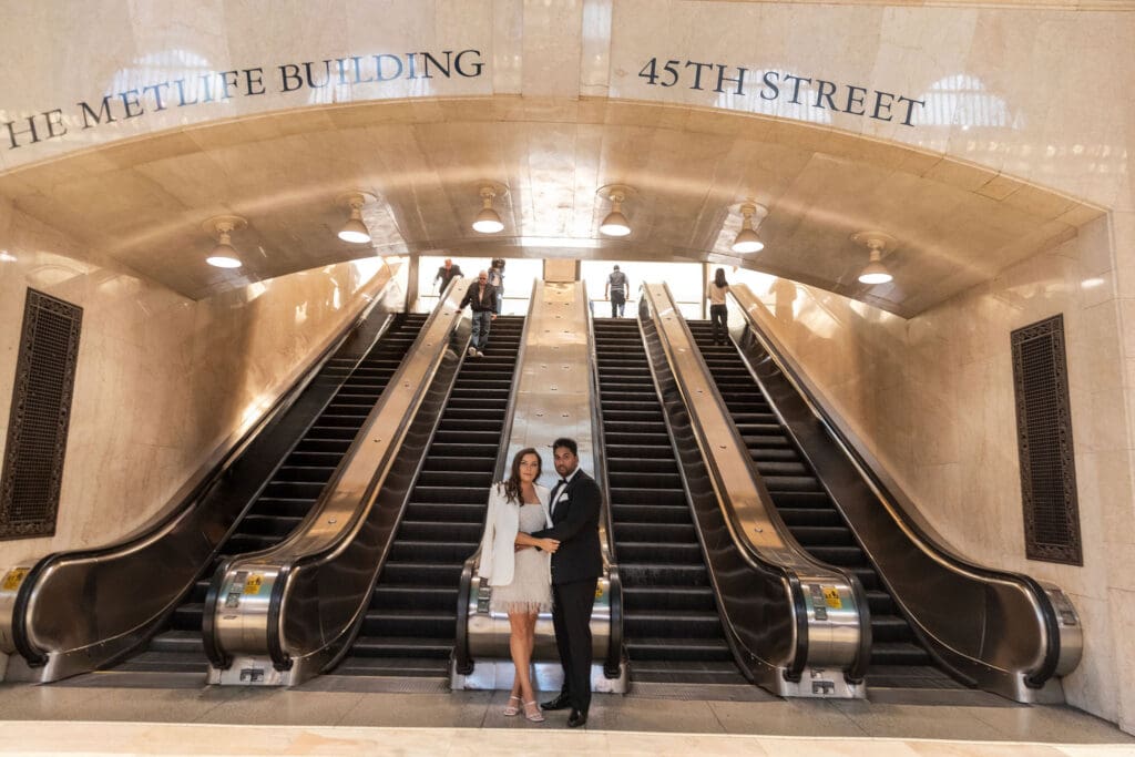 Fancy Newlywed UK couple pose near main escalators inside Grand Central Station in NYC after getting married at City Hall.
