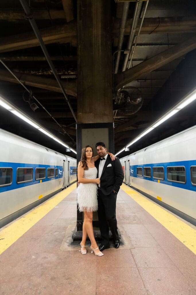 Fancy Newlywed UK couple pose on train platform inside Grand Central Station in NYC after getting married at City Hall.