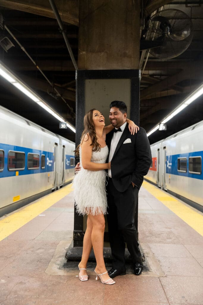 Fancy Newlywed UK couple laugh at train platform inside Grand Central Station in NYC after getting married at City Hall.