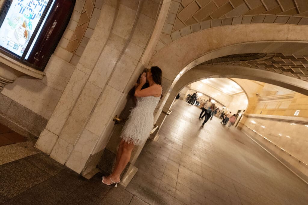 Newlywed UK couple use the whispering wall inside Grand Central Station in NYC after getting married at City Hall.