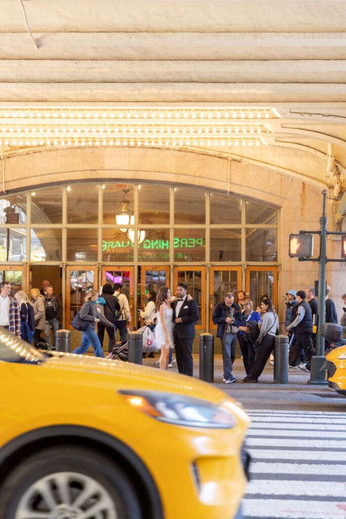 Newlywed UK couple pose in front of a taxi outside Grand Central Station in NYC after getting married at City Hall.