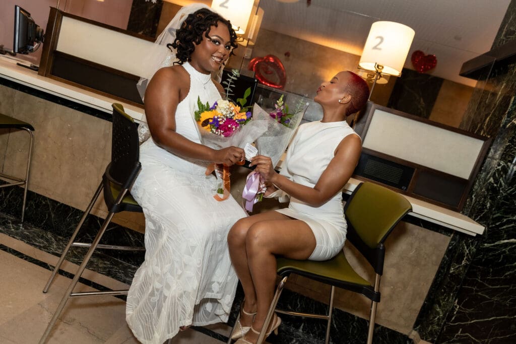Two brides pose while waiting to get married at NYC City Hall.