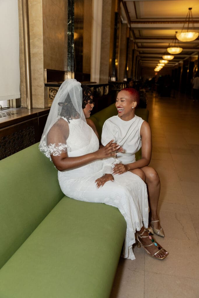 Two brides getting ready at the green couches at NYC City Hall.