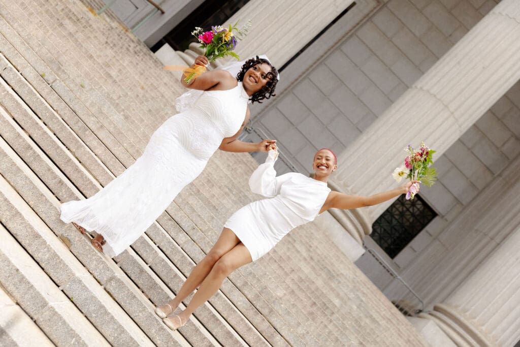Two brides on the Supreme Court steps in NYC after getting married at City Hall.