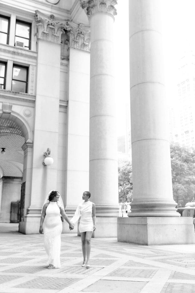 Two brides hold hands in NYC after getting married at City Hall. Black and White Image.
