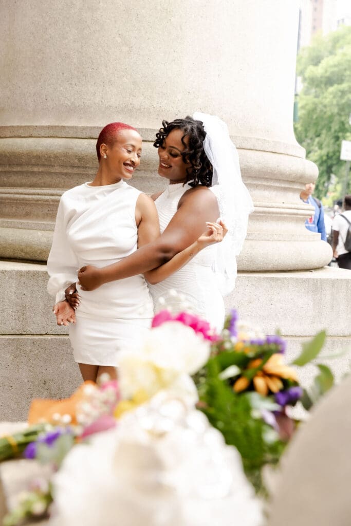 Two brides embrace NYC after getting married at City Hall.