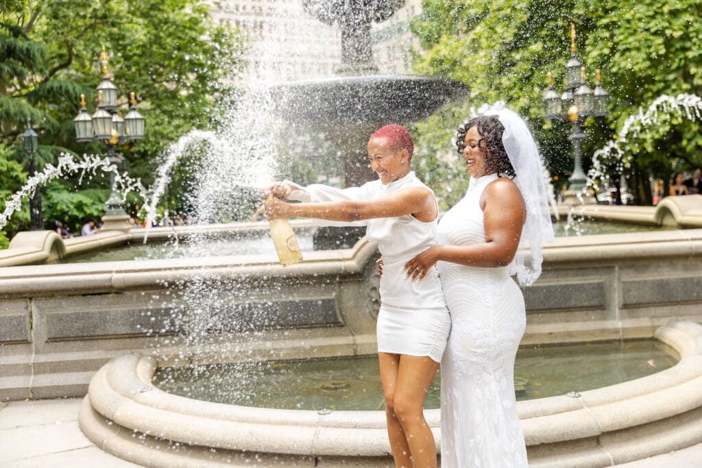 Two brides pop champagne in NYC after getting married at City Hall.