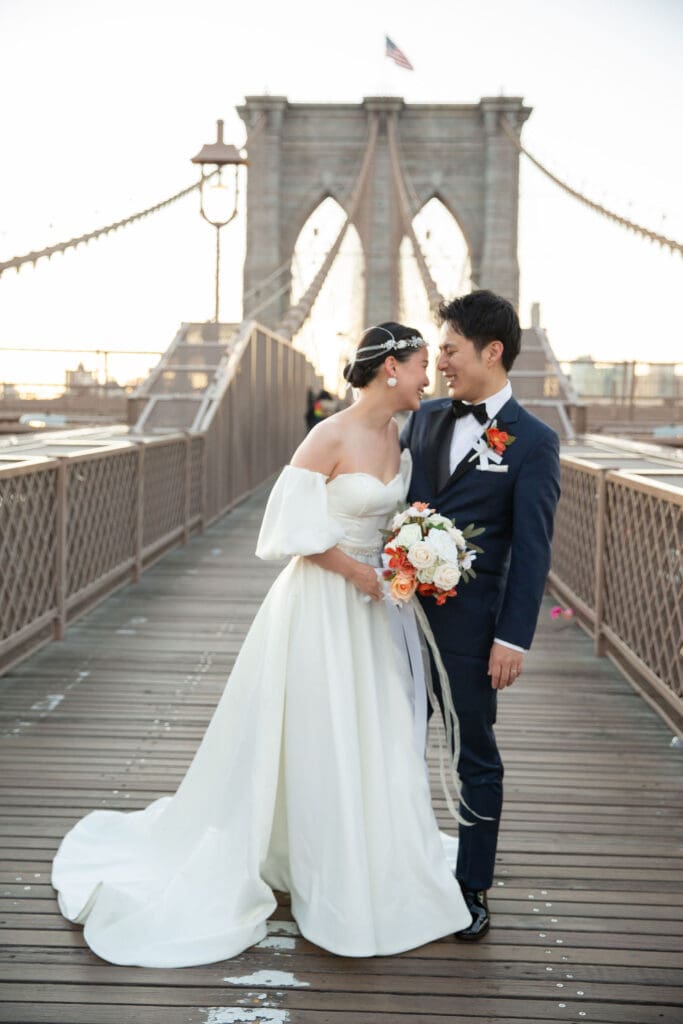 Newlyweds laugh and walk around at the Brooklyn Bridge in NYC. Black and White Image.
