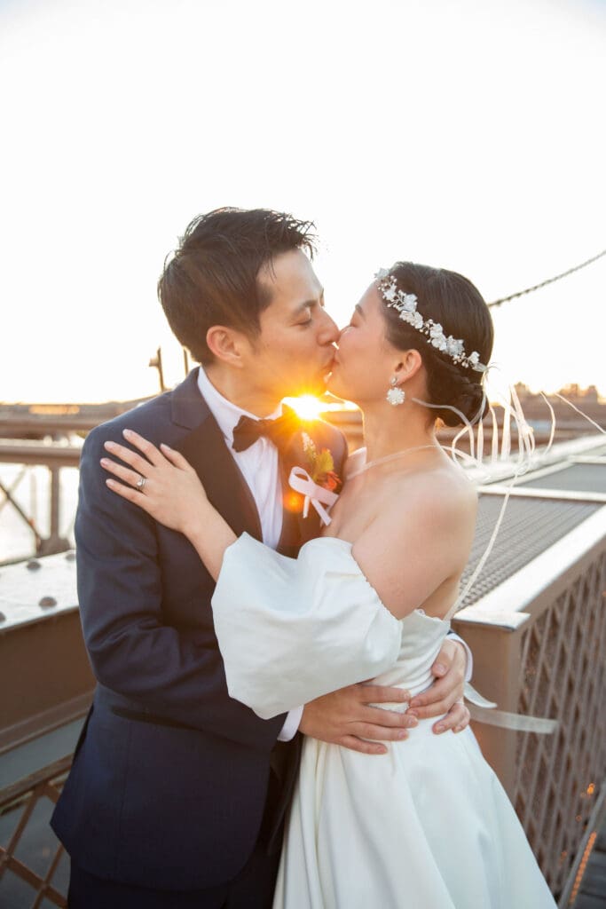 Newlyweds kiss at the Brooklyn Bridge in NYC. Black and White Image.