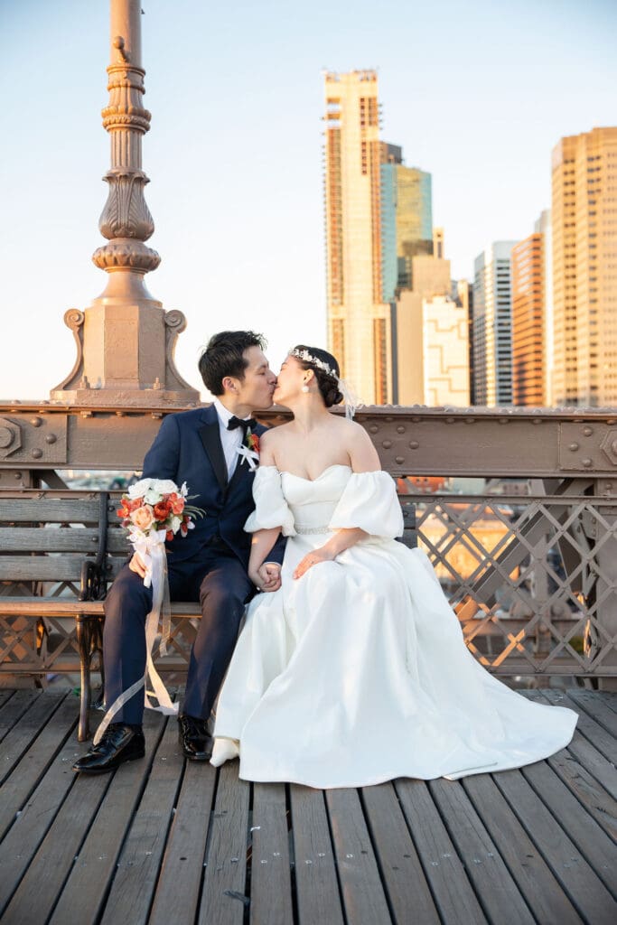 Newlyweds kiss at Brooklyn Bridge in NYC.