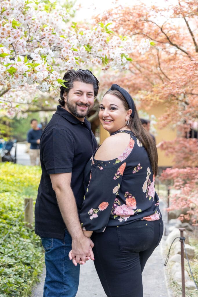 Newlywed couple take spring anniversary photos in the Japanese Garden with the cherry blossoms at the Brooklyn Botanic Garden in Brooklyn, NY.