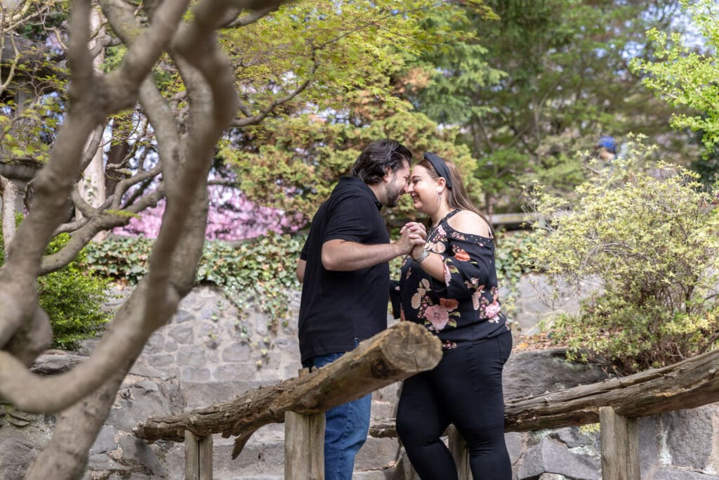 Newlywed couple take anniversary photos in the Japanese Garden with the cherry blossoms at the Brooklyn Botanic Garden in Brooklyn, NY.