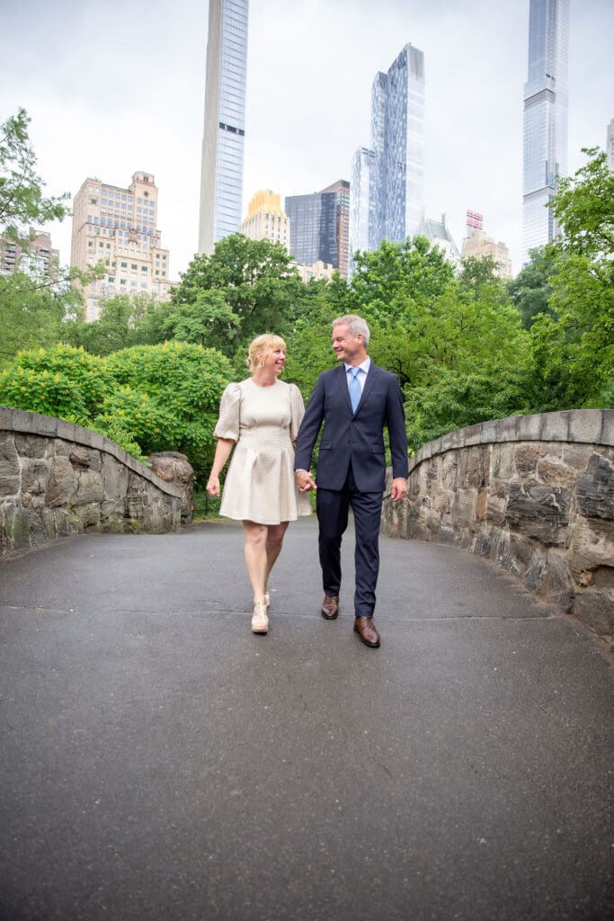 NYC Elopement in Central Park after after ceremony at the Norwegian Seamen's Church. Bride and groom walk along Gapstow Bridge.