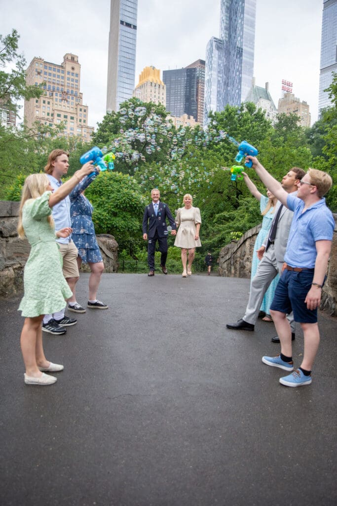 NYC Elopement in Central Park after after ceremony at the Norwegian Seamen's Church. Family blows bubbles at Bride and groom.
