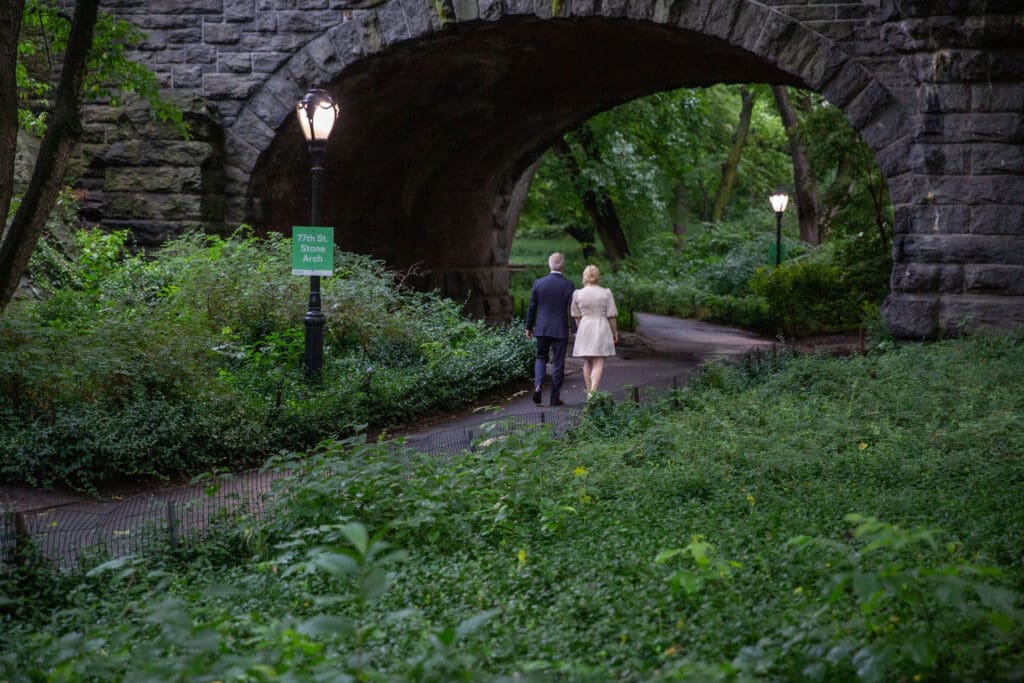NYC Elopement in Central Park after after ceremony at the Norwegian Seamen's Church. Photo of Bride and Groom from behind as they walk in the park.