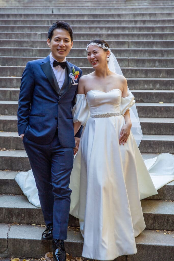 Newlyweds pose at the steps at Bethesda Terrace in NYC's Central Park.