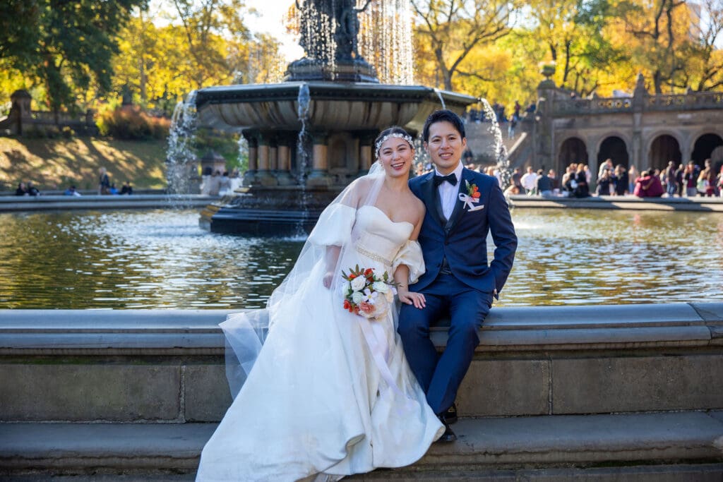 Newlyweds pose at Bethesda Terrace Fountain in NYC's Central Park.