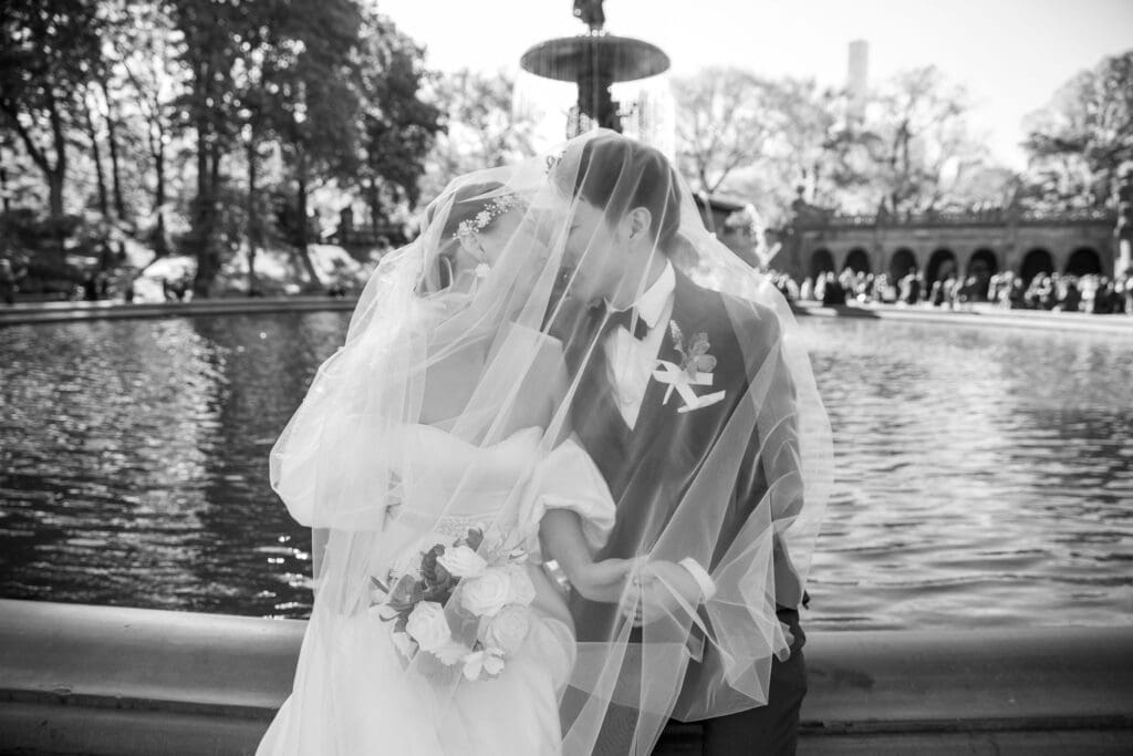 Newlyweds kiss at Bethesda Terrace Fountain in NYC's Central Park.