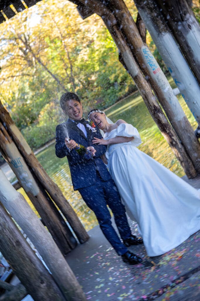 Newlyweds pop champagne at Wagner Cove in NYC's Central Park.
