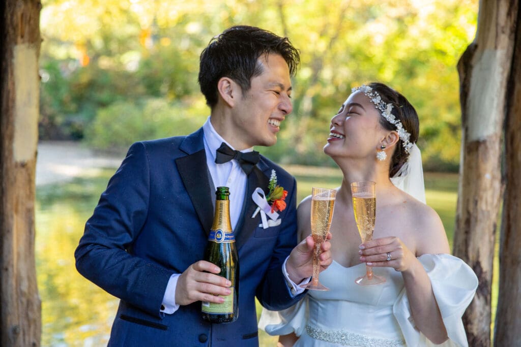 Newlyweds pop champagne at Wagner Cove in NYC's Central Park.