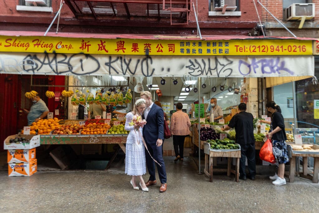 Newlyweds take wedding portraits along Mott St in Chinatown NYC.