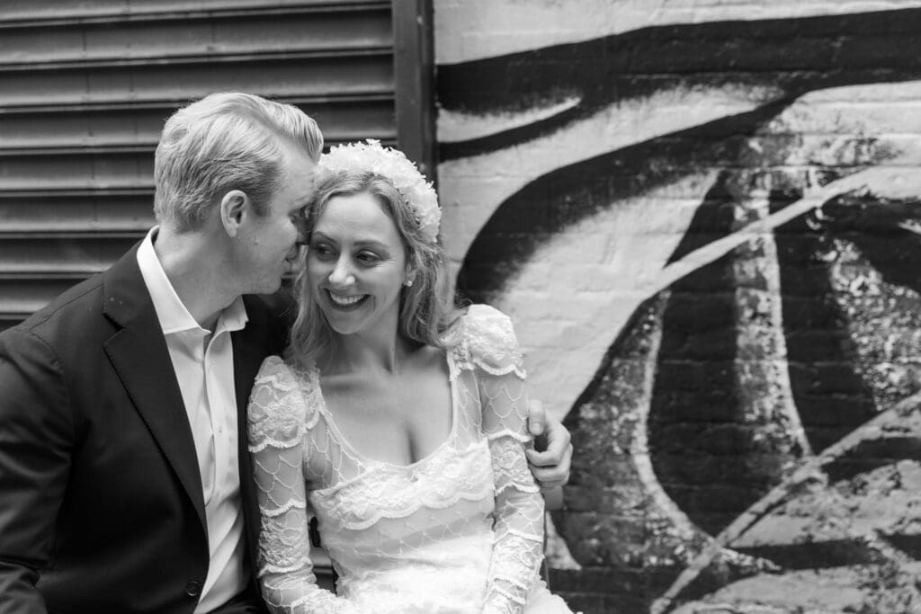 Newlyweds take wedding portraits in Chinatown NYC on Doyers Street with lanterns in background.