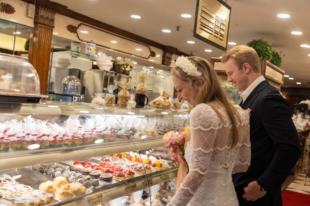 Newlyweds shop for pastries at Ferrara's in NYC's Little Italy.