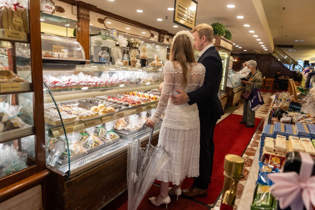 Newlyweds shop for pastries at Ferrara's in NYC's Little Italy.