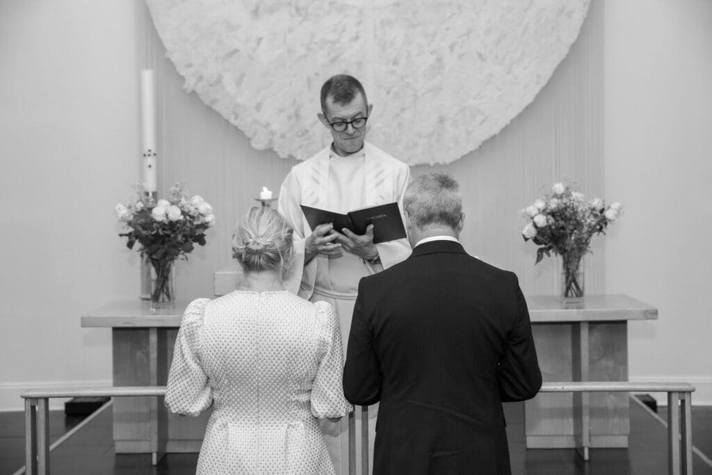 NYC Elopement at the Norwegian Seamen's Church. Bride and Groom pray during ceremony.