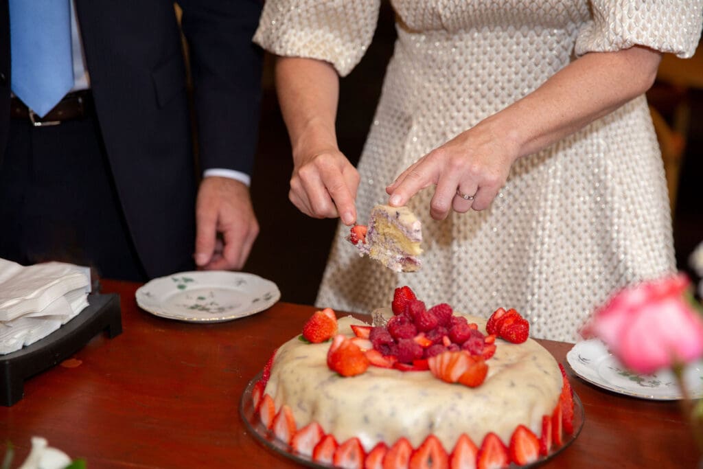 NYC Elopement at the Norwegian Seamen's Church. Bride cuts strawberry cake.