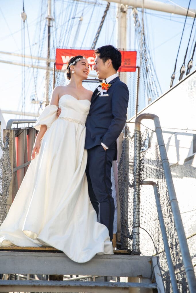 Newlyweds pose on a boat for wedding portraits in South Street Seaport in NYC.