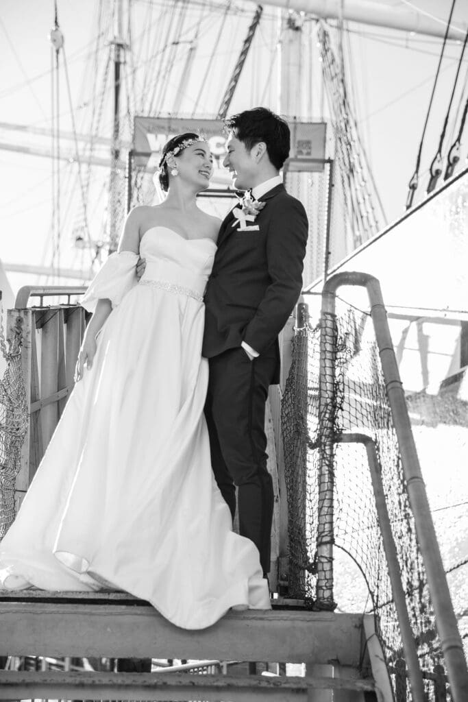 Newlyweds pose on a boat for wedding portraits in South Street Seaport in NYC.
