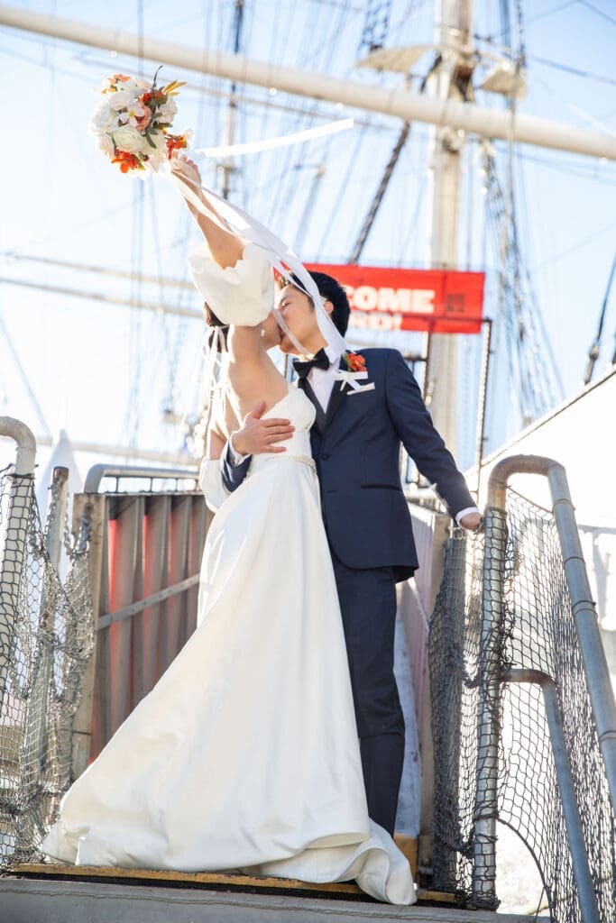 Newlyweds kiss on a boat for wedding portraits in South Street Seaport in NYC.