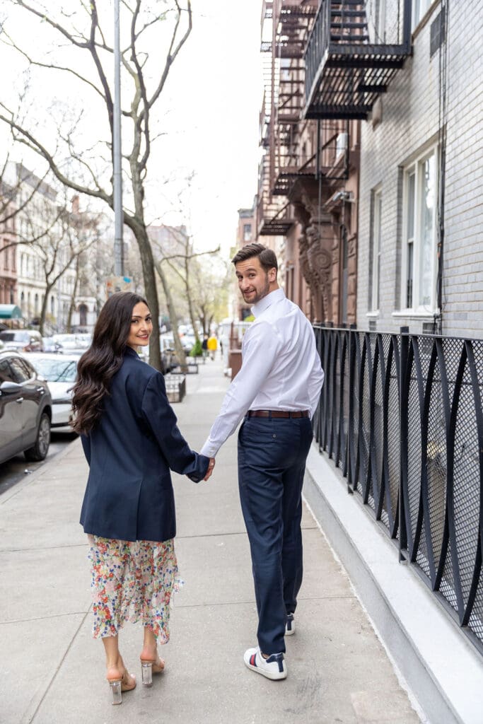 Engaged couple walk down the streets of the Upper West Side in NYC.