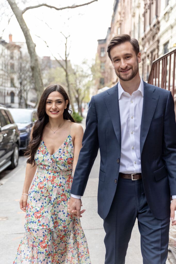 Engaged couple walk down the streets of the Upper West Side in NYC.