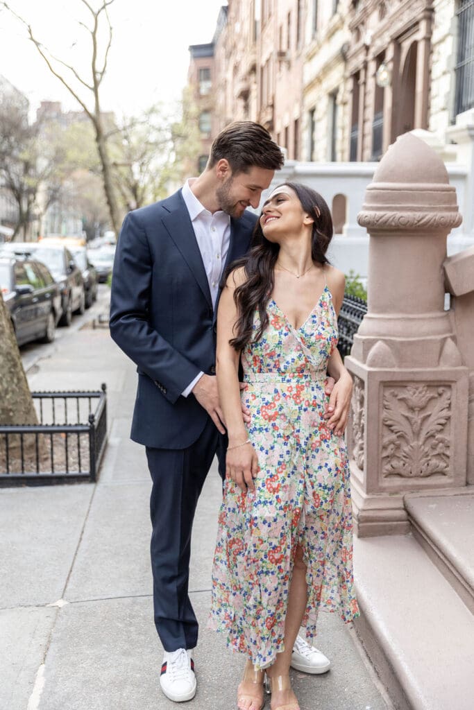 Engaged couple walk down the streets of the Upper West Side in NYC.